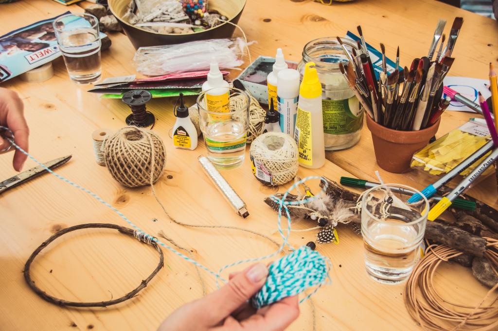 Desk full of crafting materials Photo by Jasmin Schreiber on Unsplash
